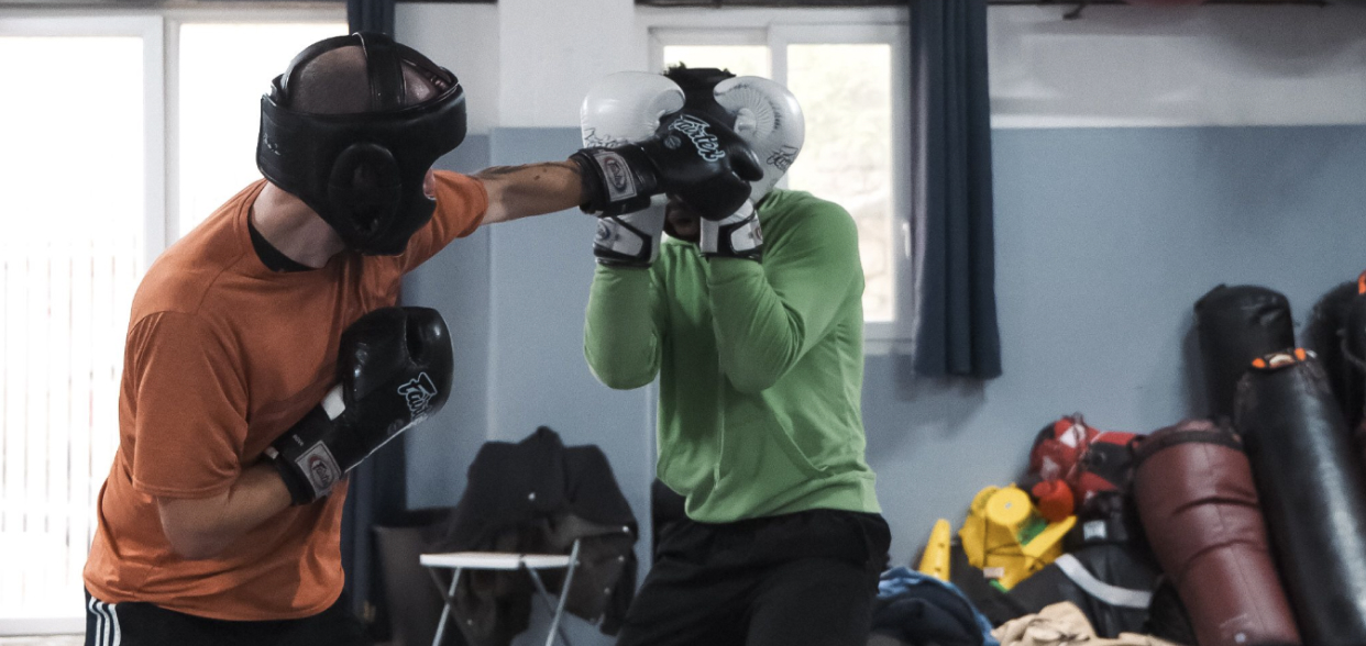 Marc, creator of the Shadow Boxing App, sparring in headgear and landing a jab on a partner with a high guard